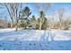 Spacious backyard, partially covered in snow, with mature trees at 4820 E 70Th St, Indianapolis, IN 46220