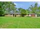 Ranch home with brick and siding, attached garage, and a spacious lawn with scattered trees at 4820 E 70Th St, Indianapolis, IN 46220