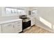Modern kitchen with white cabinets, stainless steel appliances, and light wood flooring at 4992 W 100 S, New Palestine, IN 46163