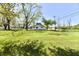 Spacious lawn with mature trees surrounding a home with vinyl siding on a beautiful, sunny day at 4992 W 100 S, New Palestine, IN 46163