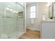 Modern bathroom with tiled walk-in shower, sleek vanity, and a window offering natural light at 5420 Mcfarland Rd, Indianapolis, IN 46227