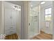 Beautiful bathroom featuring a large walk-in shower with white tile, a built-in cabinet and wood look floors at 5420 Mcfarland Rd, Indianapolis, IN 46227