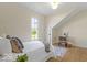 Bright bedroom featuring a bed, chair, rug, wood floors, and a window for natural light at 5420 Mcfarland Rd, Indianapolis, IN 46227
