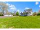Beautiful home with a screened porch, a large yard, and a separate garage, set against a backdrop of lush greenery at 5420 Mcfarland Rd, Indianapolis, IN 46227