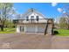 Unique exterior showcasing a barn-like home with a multi-car garage and second-story deck at 5420 Mcfarland Rd, Indianapolis, IN 46227