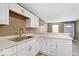 Bright kitchen featuring white cabinets, marble countertops, and stainless steel sink at 5420 Mcfarland Rd, Indianapolis, IN 46227