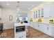 Well-lit kitchen boasts white cabinetry, a functional island with microwave, and charming pendant lighting at 5420 Mcfarland Rd, Indianapolis, IN 46227