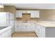 Well-lit kitchen with white cabinets and stainless steel sink overlooking the living area at 5420 Mcfarland Rd, Indianapolis, IN 46227