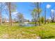 Scenic backyard pond with a fountain, surrounded by lush greenery and scattered trees at 5420 Mcfarland Rd, Indianapolis, IN 46227
