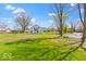 Expansive yard showcasing the home's setting, with mature trees and partial water feature at 5420 Mcfarland Rd, Indianapolis, IN 46227