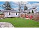 Well-maintained backyard with stone patio, lush grass, and a privacy fence at 5630 Winthrop Ave, Indianapolis, IN 46220