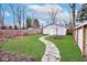 Professionally landscaped backyard with stone path, patio, and lush green lawn at 5630 Winthrop Ave, Indianapolis, IN 46220