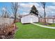 Professionally landscaped backyard with mature trees, lush green lawn, and stone pathway at 5630 Winthrop Ave, Indianapolis, IN 46220