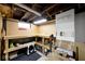 Unfinished basement area featuring a workbench with pegboard walls and storage shelves at 5630 Winthrop Ave, Indianapolis, IN 46220