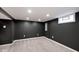 Finished basement with black accent walls, neutral carpeting, and ample lighting at 5630 Winthrop Ave, Indianapolis, IN 46220
