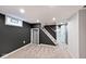 Clean basement includes stairs to the floor above, neutral walls and carpet, and lighting at 5630 Winthrop Ave, Indianapolis, IN 46220