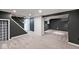 Spacious basement area with gray walls, modern carpeting, and a well-lit staircase at 5630 Winthrop Ave, Indianapolis, IN 46220