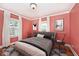 Cozy bedroom featuring salmon colored walls, plush gray carpet, and decoratively framed art at 5630 Winthrop Ave, Indianapolis, IN 46220