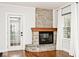 Cozy fireplace featuring a stone surround, wooden mantel, and a glass-paned door to the backyard at 5630 Winthrop Ave, Indianapolis, IN 46220