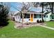Cozy home featuring a bright orange door, complemented by a green lawn and tidy landscaping at 5630 Winthrop Ave, Indianapolis, IN 46220