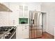 White kitchen features stainless steel appliances and subway tile at 5630 Winthrop Ave, Indianapolis, IN 46220