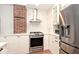 Kitchen with white cabinets, stainless steel appliances, subway tile, and a brick accent wall at 5630 Winthrop Ave, Indianapolis, IN 46220