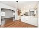 Bright kitchen features an island, stainless steel appliances, brick accent wall and white cabinetry at 5630 Winthrop Ave, Indianapolis, IN 46220