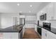 Modern kitchen with white cabinets, granite countertops, and stainless steel appliances at 6207 Preserve Way, McCordsville, IN 46055