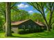 Charming single-story home with dark siding, complemented by lush green lawns and mature trees at 6220 Dean Rd, Indianapolis, IN 46220