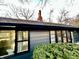 This home boasts black framed windows, gray siding, and mature greenery at 6220 Dean Rd, Indianapolis, IN 46220