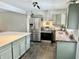Modern kitchen featuring stainless steel appliances and light green cabinetry at 6220 Dean Rd, Indianapolis, IN 46220