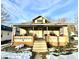 Tan house with front porch, steps, and small yard with snow at 808 S Burlington Dr, Muncie, IN 47302