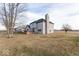 The home's backyard is complete with a small deck, a tall brick chimney, and a generous lawn at 9222 W State Road 38, Lapel, IN 46051