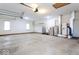 Spacious garage with concrete floor and white walls with windows, plumbing, and electrical systems exposed at 9222 W State Road 38, Lapel, IN 46051