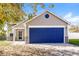 Beige house with a blue garage door, landscaping, and a partially visible white fence at 13398 N Largo Ct, Camby, IN 46113