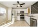 Modern kitchen with stainless steel appliances, white cabinets, and tile flooring at 13398 N Largo Ct, Camby, IN 46113