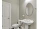 Cozy half bathroom featuring classic fixtures including a pedestal sink and oval mirror at 14565 Geist Ridge Dr, Fishers, IN 46040