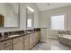Main bathroom with double sink vanity, granite countertop, and a soaking tub at 14565 Geist Ridge Dr, Fishers, IN 46040