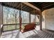 Covered porch features a wooden swing with a view of the surrounding trees at 14565 Geist Ridge Dr, Fishers, IN 46040