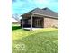 Backyard exterior showcasing a brick house with a covered patio, and a green lawn at 2212 Galleone Way, Plainfield, IN 46168