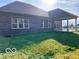 Exterior backyard featuring brick house with a covered patio, and a well-maintained lawn at 2212 Galleone Way, Plainfield, IN 46168
