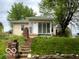 Charming home featuring a brick staircase, mature trees, and a partially enclosed front porch at 252 Ringwood Way, Anderson, IN 46013