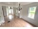 Open-concept living room featuring hardwood floors, fresh neutral paint, and classic light fixtures at 252 Ringwood Way, Anderson, IN 46013