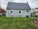 Backyard view of the house, showing three windows, a partial fence, and green grass at 3513 N Layman Ave, Indianapolis, IN 46218