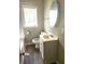 Bathroom features a sleek single sink vanity, oval mirror, and vinyl plank flooring at 3513 N Layman Ave, Indianapolis, IN 46218
