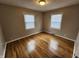Comfortable bedroom with hardwood floors, natural light from two windows, and neutral decor for relaxation at 3513 N Layman Ave, Indianapolis, IN 46218