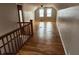 Hallway leading to a bedroom, featuring hardwood floors and views of the bright, airy upper-level area at 3513 N Layman Ave, Indianapolis, IN 46218