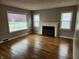 Bright living room with hardwood floors, a decorative fireplace, and natural light streaming through the windows at 3513 N Layman Ave, Indianapolis, IN 46218