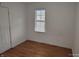 Bedroom featuring wood-look flooring, a window, and a door at 3619 N Hawthorne Ln, Indianapolis, IN 46218