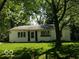 Charming single-story home with a well-manicured lawn and mature trees providing shade at 3639 Richelieu Rd, Indianapolis, IN 46226